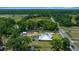 Aerial view of property with pool, outbuildings, wooded areas, and road access at 3934 Se 110Th St, Belleview, FL 34420