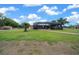 Expansive backyard featuring a screened pool enclosure and ample green space on a sunny day at 3934 Se 110Th St, Belleview, FL 34420