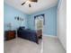 Comfortable bedroom featuring cool blue walls and neutral tile floors at 3934 Se 110Th St, Belleview, FL 34420