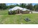 Aerial view of the exterior highlighting a well-maintained yard and multiple outbuildings at 3934 Se 110Th St, Belleview, FL 34420