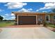 Three car garage with contemporary door design and a paved driveway at 3934 Se 110Th St, Belleview, FL 34420
