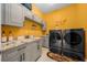 Well-equipped laundry room with modern gray appliances, granite countertops, and ample cabinet space at 3934 Se 110Th St, Belleview, FL 34420