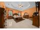 Spacious main bedroom featuring a decorative tray ceiling, ceiling fan, and matching furniture set at 3934 Se 110Th St, Belleview, FL 34420