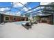 Luxurious screened-in pool area featuring ample seating, an outdoor kitchen, and tranquil surroundings at 3934 Se 110Th St, Belleview, FL 34420
