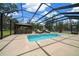 Screened-in pool area featuring a covered outdoor kitchen, pool, hot tub, lounge chairs, and ample space for entertaining at 3934 Se 110Th St, Belleview, FL 34420