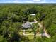 Expansive aerial view of a home nestled amidst lush greenery, showcasing its stone accents, gray roof, and beautiful surroundings at 400 Se 90Th St, Ocala, FL 34480