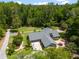Expansive aerial view of a home nestled amidst lush greenery, featuring a patio, mature trees, and well-maintained lawn at 400 Se 90Th St, Ocala, FL 34480