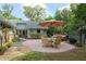 Scenic backyard view with a patio dining set, a spa, well-manicured lawn, and lush landscaping for outdoor enjoyment at 400 Se 90Th St, Ocala, FL 34480
