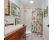 This cozy bathroom has a wood vanity and tiled shower with a decorative shower curtain at 400 Se 90Th St, Ocala, FL 34480