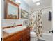 Beautiful bathroom with decorative mirror, wood vanity, sink, and tiled shower/tub combo at 400 Se 90Th St, Ocala, FL 34480