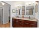 Double sink bathroom boasts granite countertop, wood cabinets, and a glass block shower at 400 Se 90Th St, Ocala, FL 34480