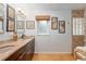 Bright bathroom featuring double sinks, framed artwork, a window, and a tiled shower at 400 Se 90Th St, Ocala, FL 34480