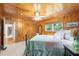 Knotty pine bedroom features a full bed, fan, and view to the hallway at 400 Se 90Th St, Ocala, FL 34480