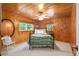 Cozy bedroom with knotty pine walls and ceiling, fan, and two windows at 400 Se 90Th St, Ocala, FL 34480