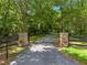 A driveway gate with stone columns and hanging planters with flowering plants at 400 Se 90Th St, Ocala, FL 34480