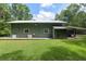 Side of the house with green painted panels, gray trim and a concrete patio at 400 Se 90Th St, Ocala, FL 34480