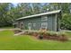 Unique green home featuring a metal roof, inviting porch with seating, and well-maintained landscaping at 400 Se 90Th St, Ocala, FL 34480