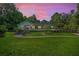 Stunning evening view of a charming home with a well-manicured lawn and lush landscaping, showcasing curb appeal at 400 Se 90Th St, Ocala, FL 34480