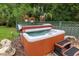 Inviting hot tub with a step-up platform, surrounded by lush greenery, offering a private and relaxing outdoor experience at 400 Se 90Th St, Ocala, FL 34480