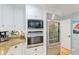 Kitchen featuring stainless steel appliances, built-in shelving and stone countertops at 400 Se 90Th St, Ocala, FL 34480