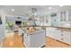 Spacious kitchen features an island, stainless steel range hood, and views into the living room at 400 Se 90Th St, Ocala, FL 34480