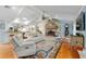 Cozy living room boasts a stone fireplace, wood floors, white furniture, and an open layout at 400 Se 90Th St, Ocala, FL 34480