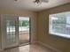 Bedroom with tile flooring, ceiling fan, large window, and glass doors to screened patio at 439 Sw Shorewood Dr, Dunnellon, FL 34431