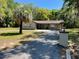 Attractive home showcasing a paved driveway, mature palm and a lush green lawn at 439 Sw Shorewood Dr, Dunnellon, FL 34431
