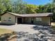 Charming home featuring a paved driveway and a well-maintained yard with mature trees at 439 Sw Shorewood Dr, Dunnellon, FL 34431