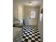 A laundry room with black and white checkered floors, a door to the backyard, washer, and hot water heater at 439 Sw Shorewood Dr, Dunnellon, FL 34431