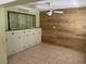 A room with wooden accents on the wall and built-in cabinets; ceiling fan and tiled floors throughout at 439 Sw Shorewood Dr, Dunnellon, FL 34431