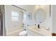 A bright bathroom with a shower, sink, toilet, and round mirror above the sink at 4757 Nw 45Th Ct, Ocala, FL 34482
