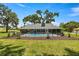 Charming backyard features a refreshing pool, fenced for privacy, and mature trees for shade at 5326 Nw 76Th Ct, Ocala, FL 34482
