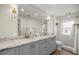 Bathroom with a double vanity, marble countertop, and a glass-enclosed shower at 5326 Nw 76Th Ct, Ocala, FL 34482
