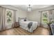 Bright bedroom with hardwood floors, black metal bed frame, and two windows offering natural light at 5326 Nw 76Th Ct, Ocala, FL 34482