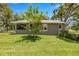 Beautiful home exterior featuring a well-manicured lawn, wood shutters, and mature landscaping at 5326 Nw 76Th Ct, Ocala, FL 34482