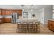 Kitchen with wood floors, stainless steel appliances, wood cabinets, and an island with bar seating at 5326 Nw 76Th Ct, Ocala, FL 34482