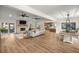 Spacious living room with a fireplace, wood floors, and an open-concept design flowing into the kitchen and dining area at 5326 Nw 76Th Ct, Ocala, FL 34482