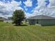View of large backyard and side of home, featuring ample green space and mature trees at 56 Walnut Dr, Ocala, FL 34480