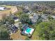 Aerial view of a community featuring a pool, golf course, lake and residences surrounded by mature trees at 588 Fairways Ln # E204, Ocala, FL 34472