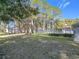 Grassy common area with mature trees and landscaping, offering a serene outdoor space for residents at 588 Fairways Ln # E204, Ocala, FL 34472