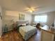 Comfortable bedroom featuring wood flooring, a ceiling fan, and coordinated furnishings at 588 Fairways Ln # E204, Ocala, FL 34472