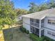 Exterior view of a multi-story building with screened-in balcony with view of pool, surrounded by manicured landscaping at 588 Fairways Ln # E204, Ocala, FL 34472