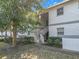 Charming condo with stucco facade and landscaped front yard entrance under a sunny sky at 588 Fairways Ln # E204, Ocala, FL 34472
