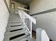 Exterior condo stairway with gray steps and white railings, well maintained with black step strips at 588 Fairways Ln # E204, Ocala, FL 34472