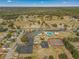 Aerial view of community amenities: a clubhouse, swimming pool, tennis courts, and ample parking in a scenic setting at 6263 Sw 107Th St, Ocala, FL 34476
