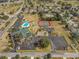 Aerial shot of community facilities including a pool, tennis courts, clubhouse, and parking lot, amidst residential homes at 6263 Sw 107Th St, Ocala, FL 34476
