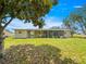 View of backyard featuring mature trees, green lawn and an inviting screened-in patio at 6263 Sw 107Th St, Ocala, FL 34476