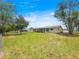 Spacious backyard with mature trees and a screened-in patio, perfect for relaxing and entertaining at 6263 Sw 107Th St, Ocala, FL 34476