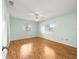 Bright bedroom featuring hardwood floors, ceiling fan and two windows overlooking the backyard at 6263 Sw 107Th St, Ocala, FL 34476